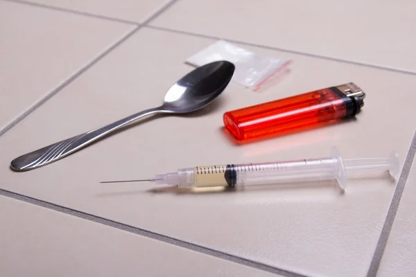 Jeringa de droga, heroína en polvo, cuchara y encendedor en el piso en b — Foto de Stock