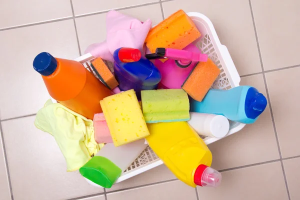 Full box of cleaning supplies on tiled floor — Stock Photo, Image