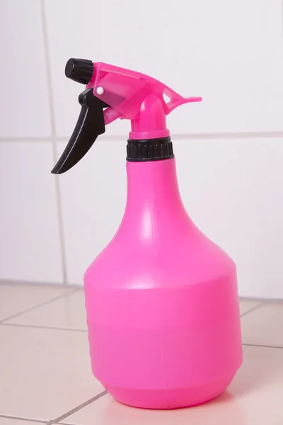 Pink plastic bottle of cleaning product on tiled floor — Stock Photo, Image