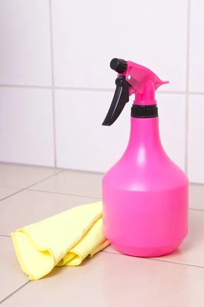 Pink plastic bottle of cleaning product and duster on tiled floo — Stock Photo, Image