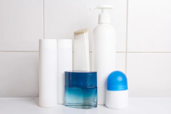 Conjunto de frascos cosméticos sobre parede em azulejo branco — Fotografia de Stock