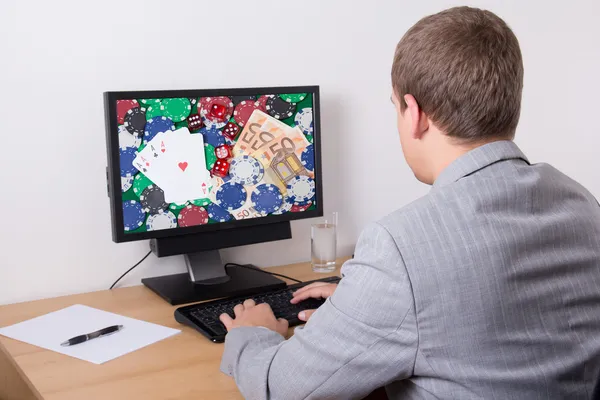 Young man in suit playing poker in internet — Stock Photo, Image