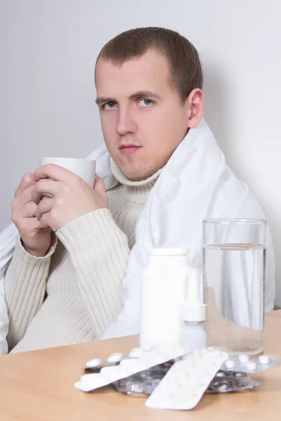 Ill man drinking tea in living room — Stock Photo, Image