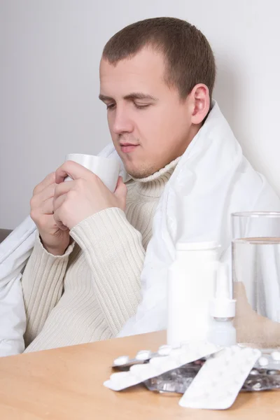 Enfermo joven hombre tomando té en la sala de estar — Foto de Stock