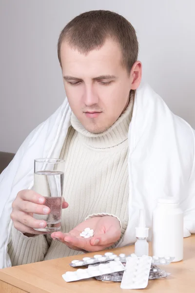 Homem doente tomando pílulas na sala de estar — Fotografia de Stock
