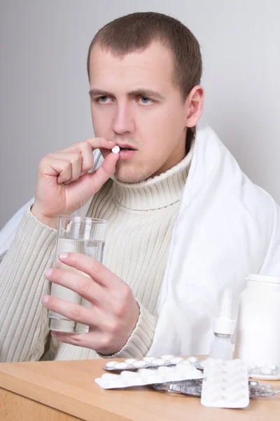 Hombre enfermo tomando pastillas en sala de estar — Foto de Stock