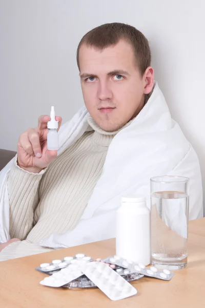 Uomo malato mostrando spray nasale in salotto — Foto Stock
