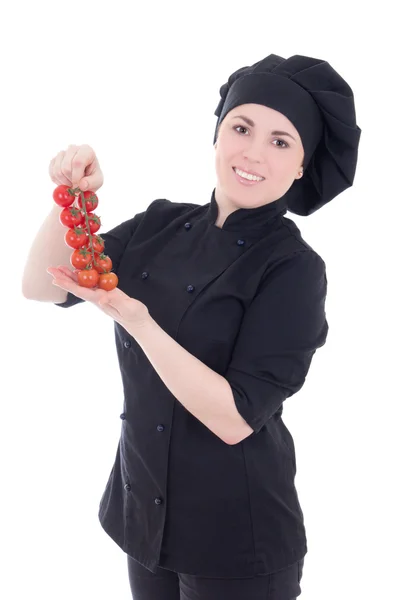 Молода кулінарна жінка в чорній формі з помідорами ізольована на білому — стокове фото