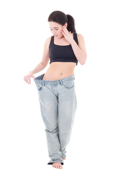 Beautiful slim excited woman in big jeans with isolated on white — Stock Photo, Image