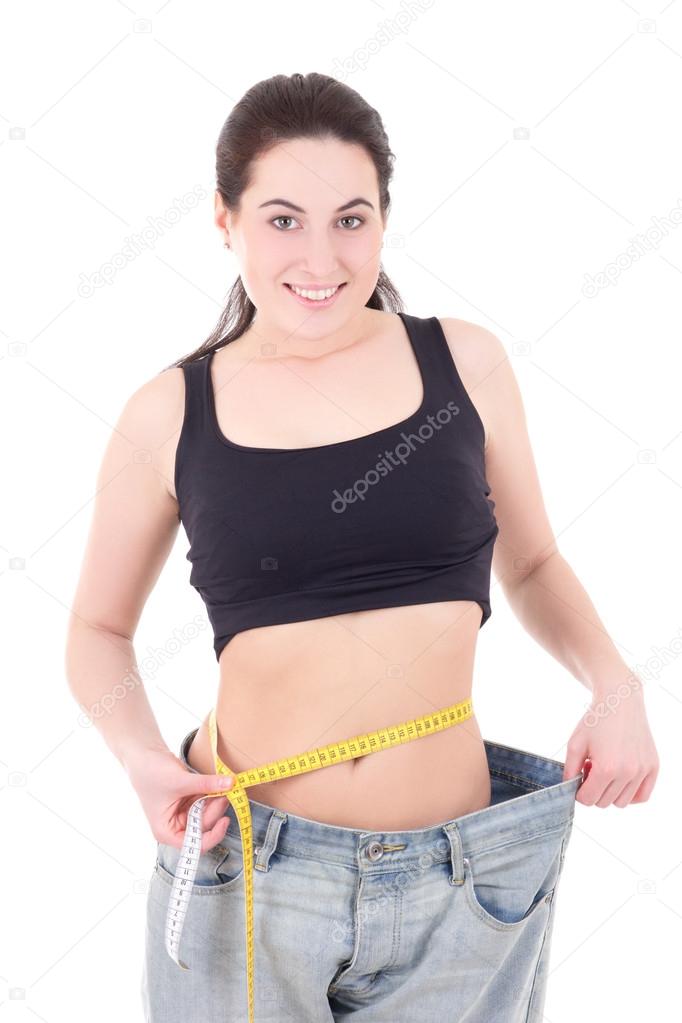 beautiful slim woman in big jeans with measuring tape isolated