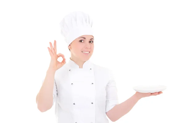 Portrait de femme jeune cuisinier en uniforme avec une assiette vide montrant — Photo