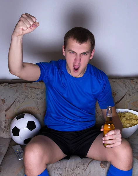 Joven divertido viendo fútbol en tv y celebrando la meta —  Fotos de Stock