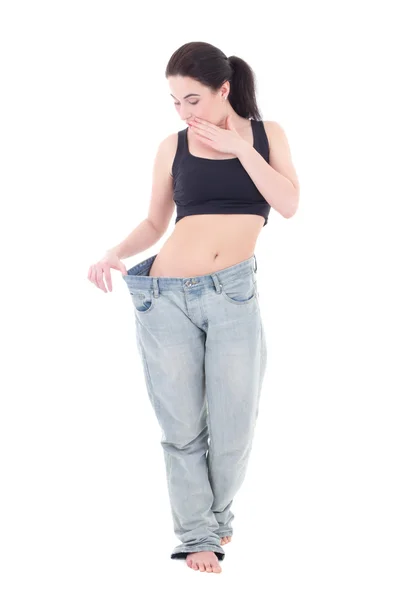 Jonge mooie slanke opgewonden vrouw in grote jeans met geïsoleerd op — Stockfoto