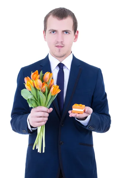 Jonge man in pak houden de doos van de gift met trouwring en bloemen — Stockfoto