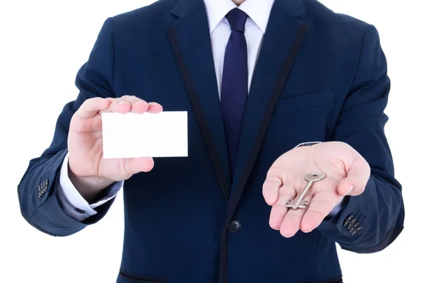 Close up of key and visiting card in male real estate agent hand — Stock Photo, Image