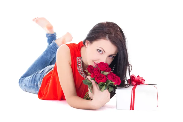 Joven hermosa mujer acostada con regalo caja y flores aislada o — Foto de Stock