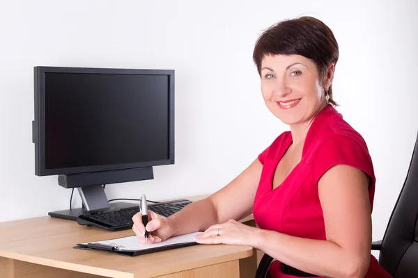 Middle aged businesswoman sitting in office — Stock Photo, Image