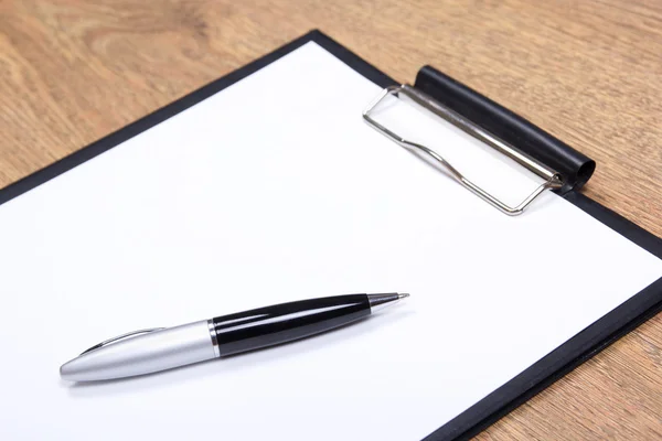 Close up of clipboard and pen on wooden table — Stock Photo, Image