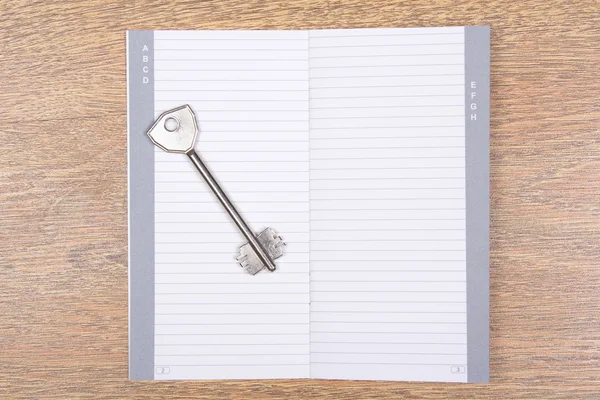 Empty phone book with key on wooden table — Stock Photo, Image