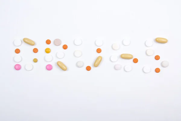 Drugs word text made of colorful tablets, pills and capsules — Stock Photo, Image