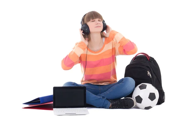 Tienermeisje in koptelefoon zitten met laptop geïsoleerd op wit — Stockfoto