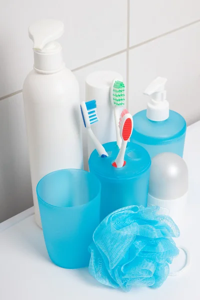 Set of blue hygiene supplies over tiled wall in bathroom — Stock Photo, Image