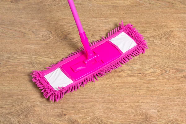 Cleaning wooden floor with pink mop — Stock Photo, Image