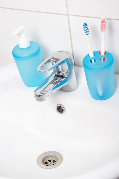 Close up of tooth brushes and soap on sink — Stock Photo, Image