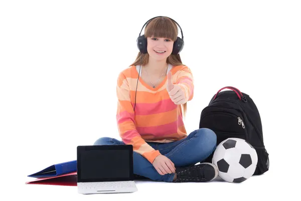 Sitting teenage girl listening music in headphones with laptop — Stock Photo, Image