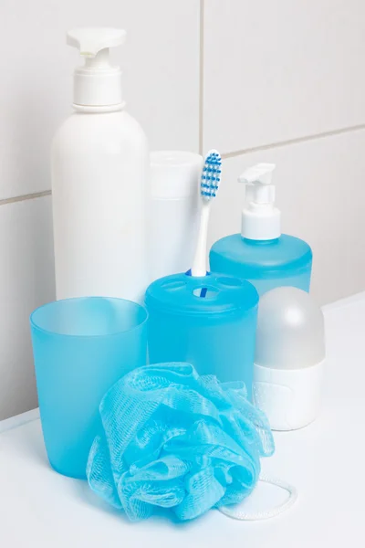 Conjunto de suministros de higiene sobre paredes de azulejos blancos en baño —  Fotos de Stock