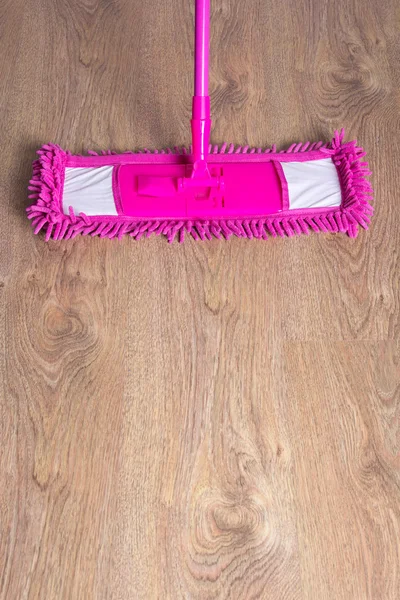 Close up of wooden parquet floor with pink mop — Stock Photo, Image