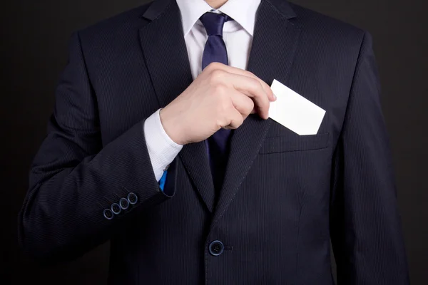 Empresario sosteniendo la tarjeta de visita de su traje de bolsillo — Foto de Stock