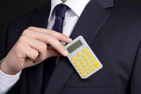 Business man putting calculator into pocket — Stock Photo, Image