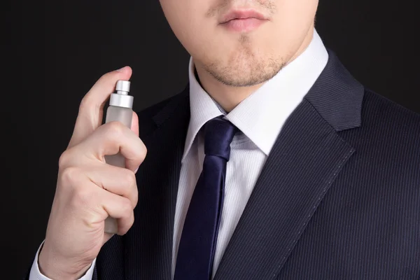 Homem de negócios jovem bonito usando perfume — Fotografia de Stock