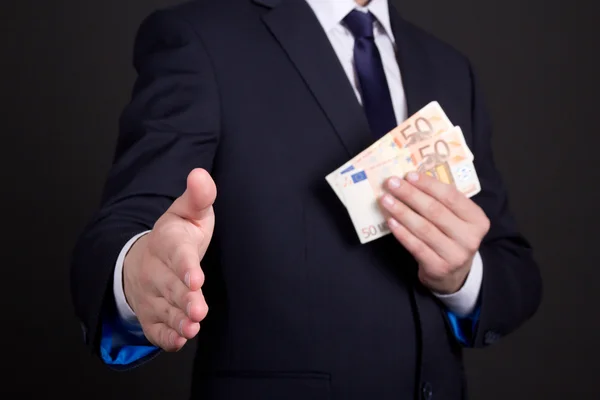 Bribery concept - man in suit with money ready to handshake — Stock Photo, Image