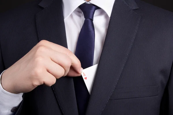 Mans hand hiding ace card in suit pocket — Stock Photo, Image