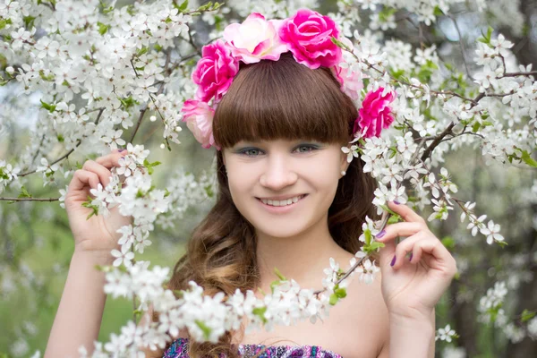 Happy young woman and blooming tree — Stok Foto