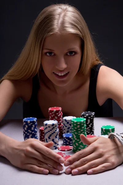 Mooie blonde vrouw met poker chips in casino — Stockfoto