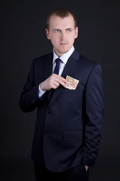 Jeune homme en affaires adapter mettre billet en euros dans la poche — Photo