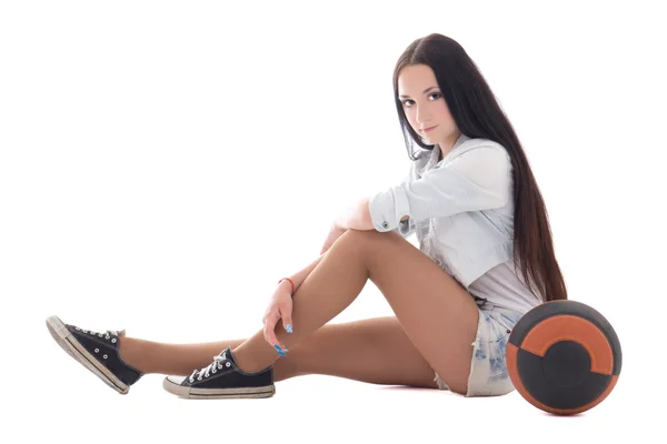 Cute teenager in denim sitting with ball — Stock Photo, Image