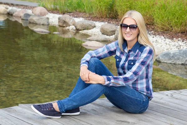 Beautiful teenage girl sitting in park — Stock Photo, Image