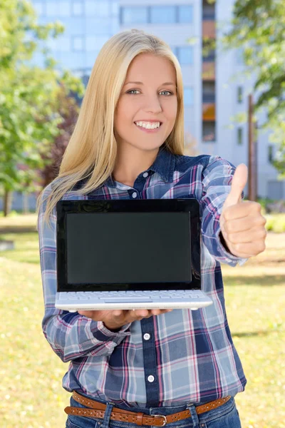 Mulher bonita com laptop polegares para cima no parque — Fotografia de Stock