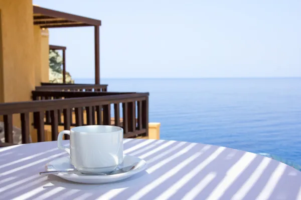 Cup of coffee on terrace with sea view — Stock Photo, Image