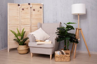 Evin içinde beton duvarın üzerinde rahat bir koltuk var.