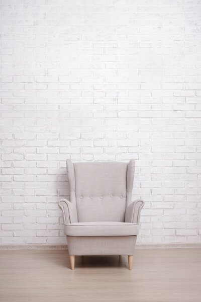 Armchair with copy space over white brick wall background