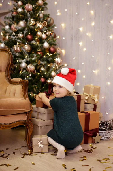 Noel Baba Şapkalı Küçük Kız Noel Ağacının Yanında Hediye Alıyor — Stok fotoğraf