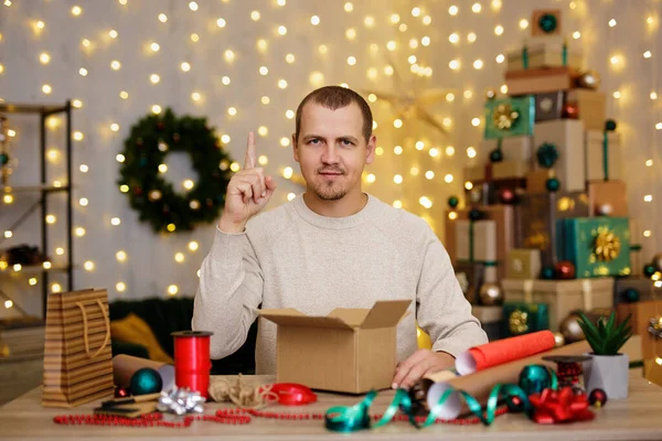 ジェスチャーアイデアと男座っていると家でクリスマスプレゼントを包む — ストック写真