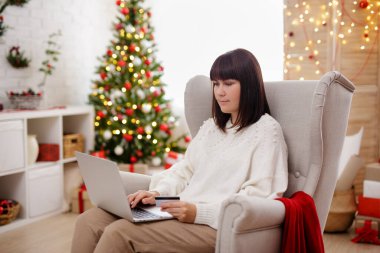 Evde kredi kartıyla online alışveriş yapan bir kadın.