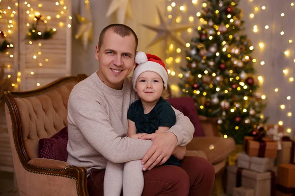 快乐的父女俩坐在圣诞树旁的沙发上 — 图库照片