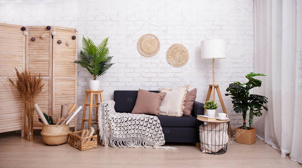 Room with sofa, lamp and plants over brick wall background